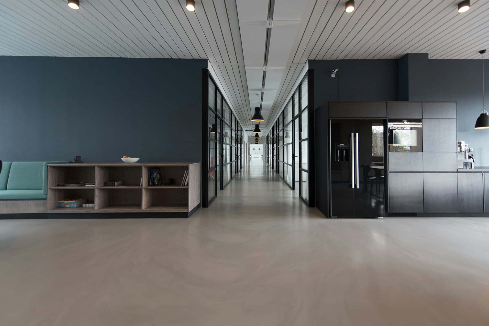 Quiet modern commercial interior with glass partitions and concrete flooring